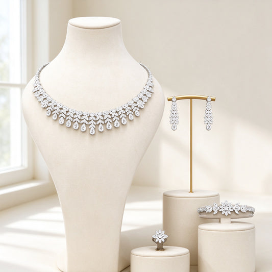 The Seraphine Bridal Set – silver-tone CZ collar necklace with teardrop fringe, linear earrings, star-flower bracelet and floral ring on an ivory background