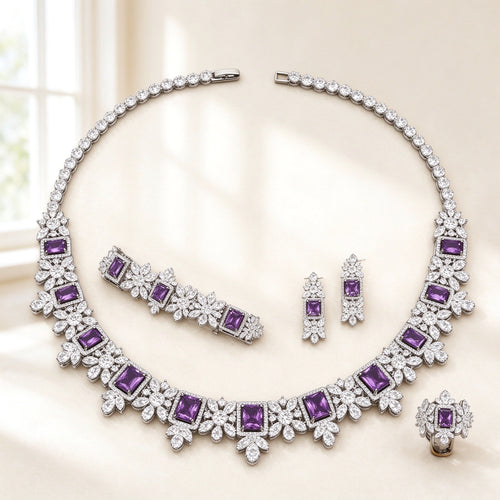 The Arabella Bridal Parure — silver-tone floral collar necklace with emerald-cut purple CZ stations, drop earrings, bracelet and ring on an ivory background