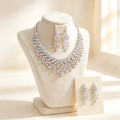 The Vivienne Bridal Parure — silver-tone cascading marquise and pear CZ fringe bib necklace with chandelier drop earrings on an ivory velvet bust