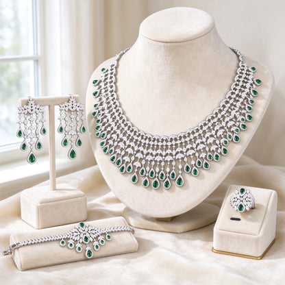 The Sage Crystal Parure — silver-tone CZ bridal set with emerald-green drops on cream velvet