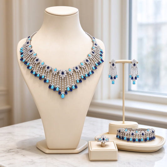 The Celestine Bridal Parure silver-tone fringe necklace with turquoise and navy pear drops on cream velvet bust