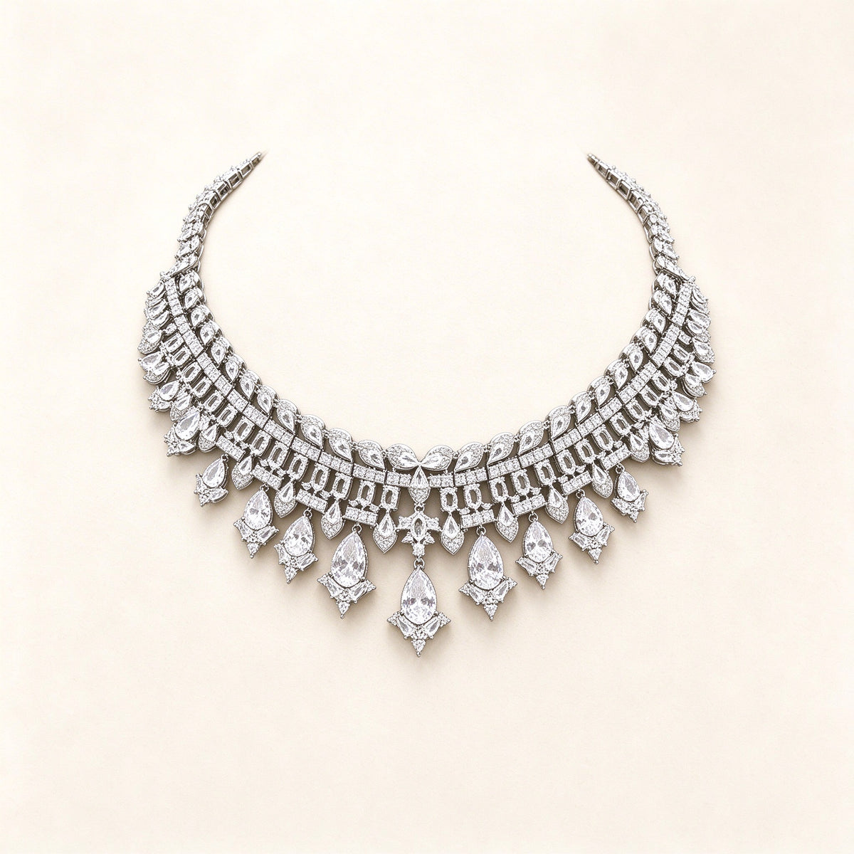 The Quinn Crystal Parure – silver-tone pavé CZ articulated collar bib necklace with pear-drop fringe on ivory
