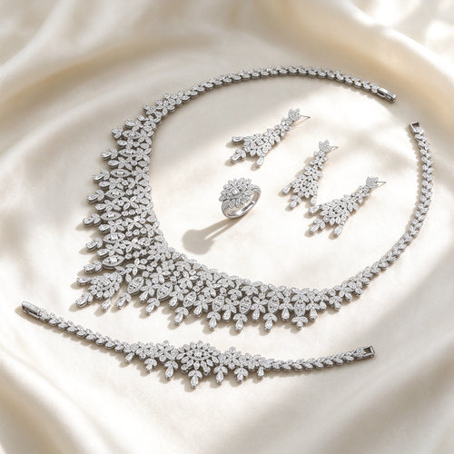 The Selene Bridal Parure — silver-tone pavé botanical fringe collar necklace, chandelier drop earrings, fringe bracelet and leaf-cluster ring on ivory silk
