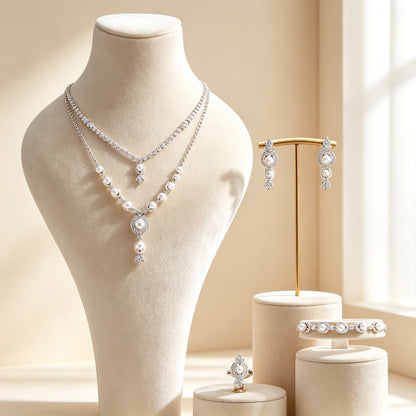 The Zenith Bridal Parure — two-layer pearl and CZ lariat necklace on cream velvet bust