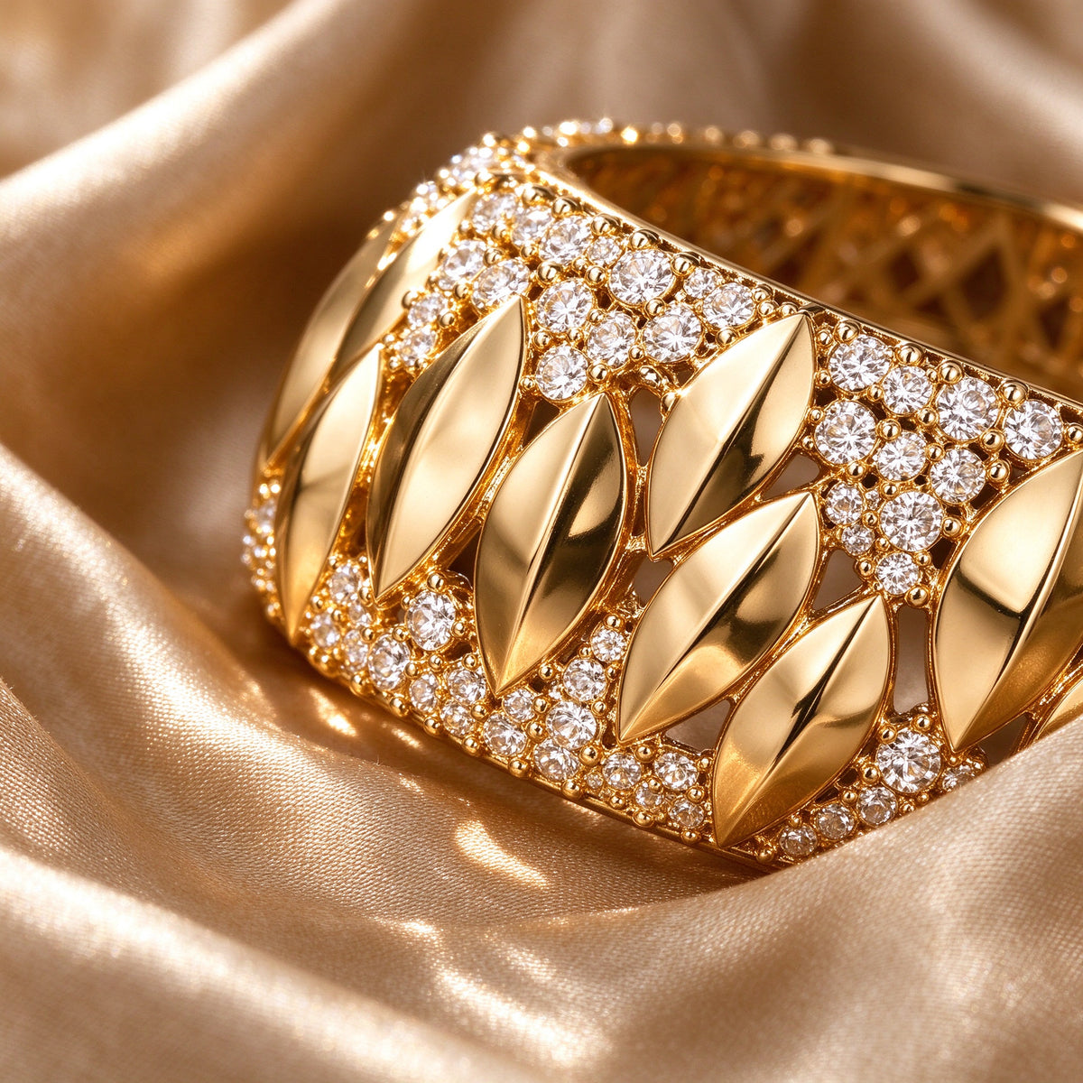 Macro detail of polished gold marquise elements and clear CZ pavé on champagne silk