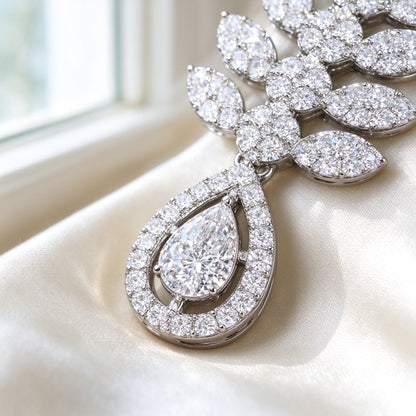 Macro close-up of the double-halo pear teardrop pendant and surrounding marquise-leaf pavé