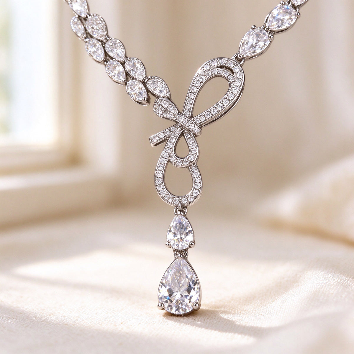 The Cameron Bridal Set – macro of the intertwined pavé CZ ribbon-loop bow with graduating pear drops