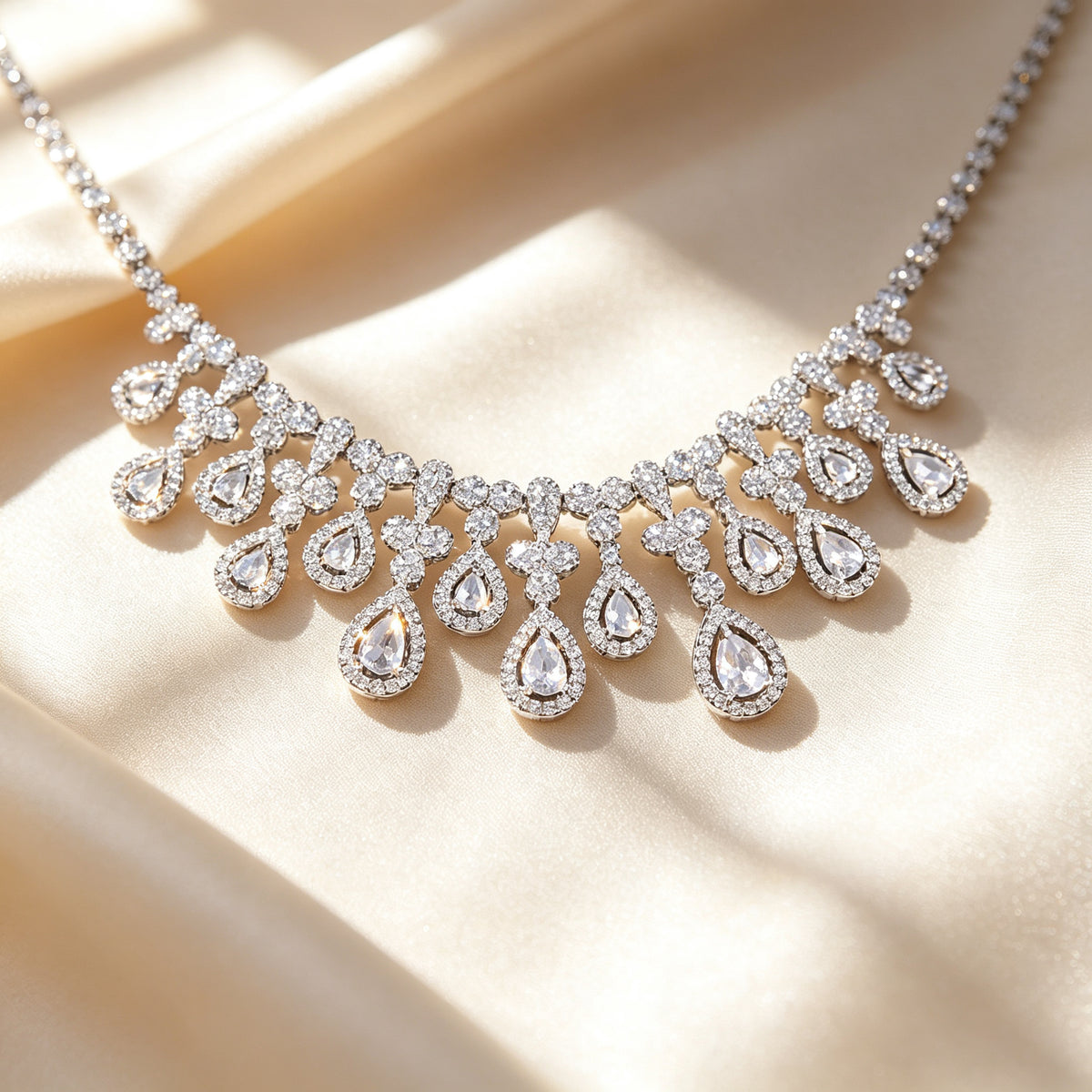 Macro close-up of The Rosalie graduated pear-shaped teardrop cubic zirconia halo fringe on ivory silk