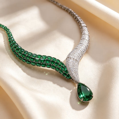 Macro close-up of The Ophelia ribbon necklace showing oval emerald cubic zirconia blending into pavé clear CZ on ivory silk