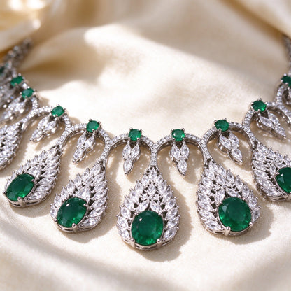 Macro detail of The Zinnia Bridal Parure fringe collar necklace showing leaf CZ frames around green oval stones