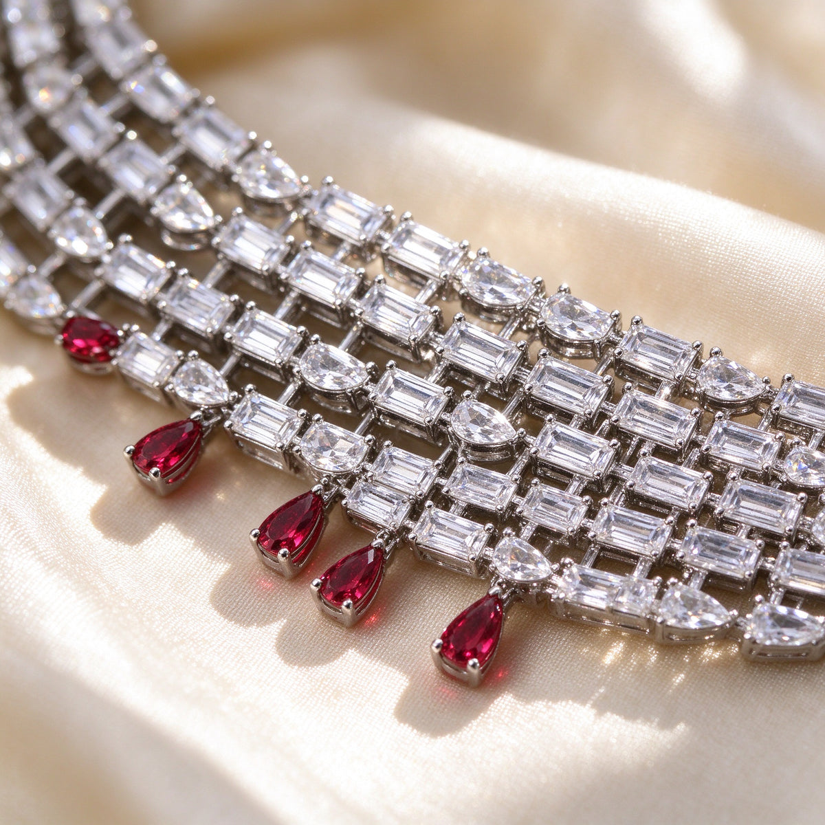 Macro of The Maeve Bridal Parure baguette-cut cubic zirconia rows with dangling ruby-red pear drops