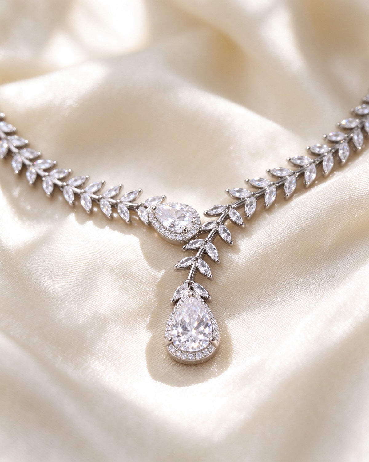 Macro of marquise-cut laurel leaves and pear-cut CZ pendant on rhodium silver-tone