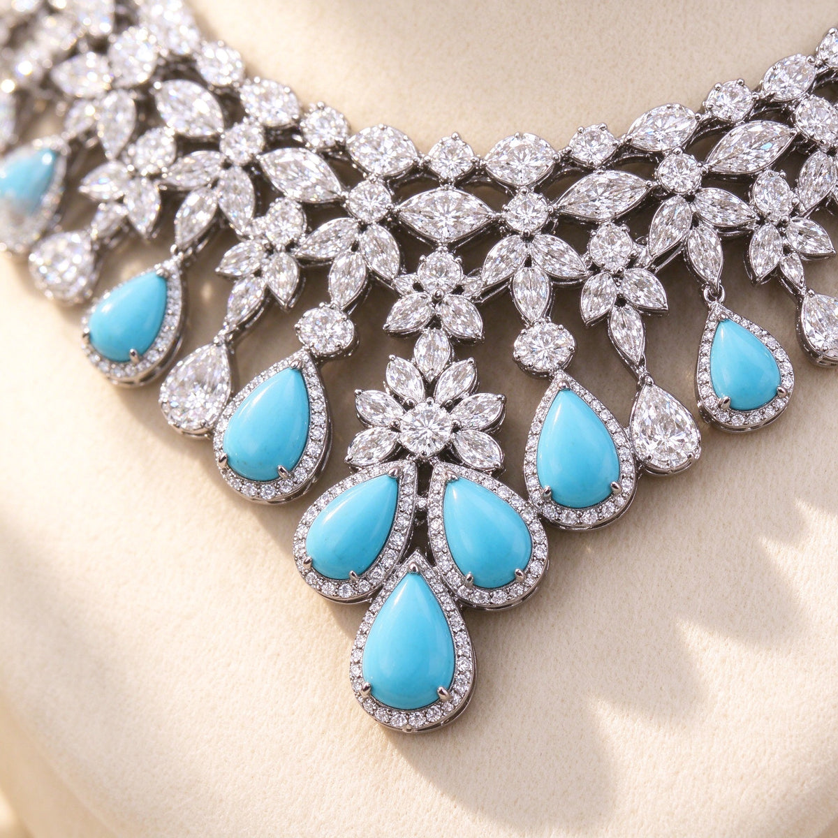 Macro close-up of a turquoise pear-shaped cubic zirconia drop surrounded by clear CZ floral clusters