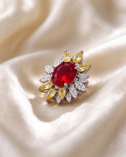 Macro of ruby-red oval CZ, canary-yellow pear petals and clear pavé leaves in silver-tone