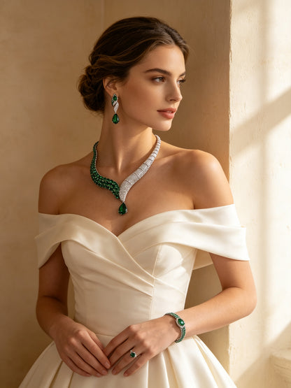 Bride in an ivory off-shoulder gown wearing The Ophelia Crystal Par emerald ribbon necklace, ribbon earrings and gradient bracelet