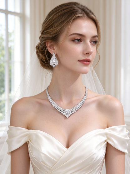Bride in an ivory off-shoulder silk gown wearing The Sutton Bridal Parure V-collar necklace and teardrop chandelier earrings