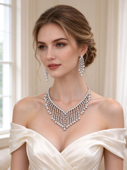 Bride in an ivory off-shoulder silk gown wearing The Oriana Crystal Parure fringe bib necklace and long fringe earrings