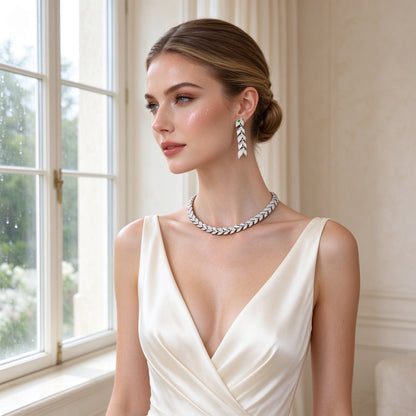 Western bride wearing The Lumina Crystal Set pavé serpent choker necklace and snake-head drop earrings in an ivory silk gown by a bright window