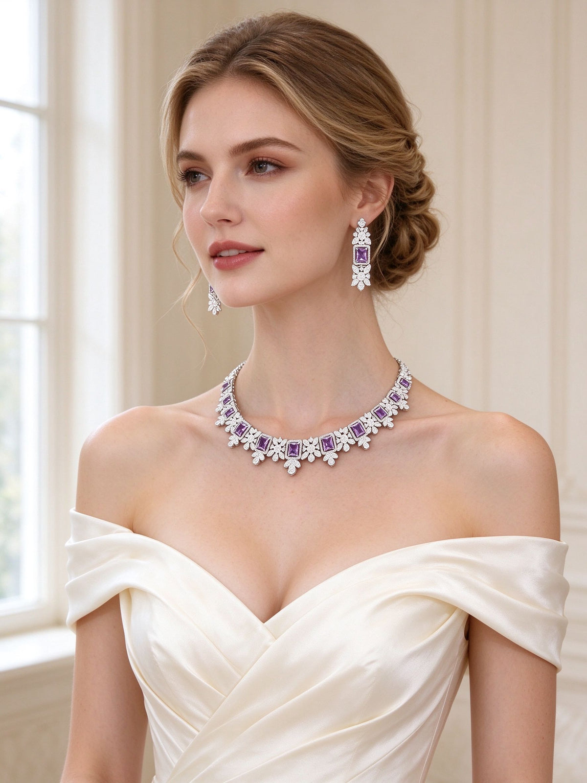 Bride in an ivory off-shoulder silk gown wearing The Arabella Bridal Parure floral necklace and purple-CZ drop earrings