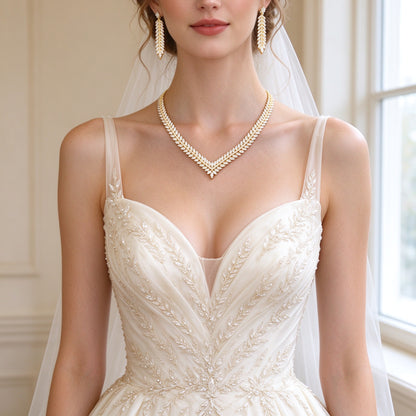 Western bride wearing The Daybreak Wedding Suite V-chevron marquise laurel necklace and long tapered leaf drop earrings in soft window light