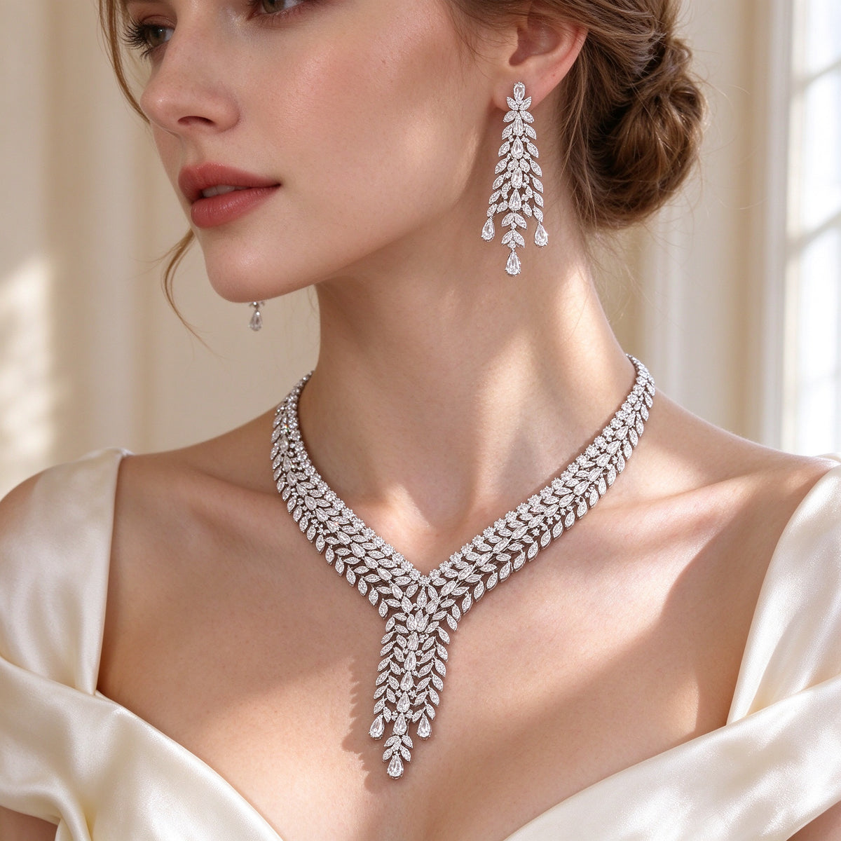 Side detail of The Peyton V-shaped cascading leaf CZ necklace along the collarbone and a leaf-cluster earring