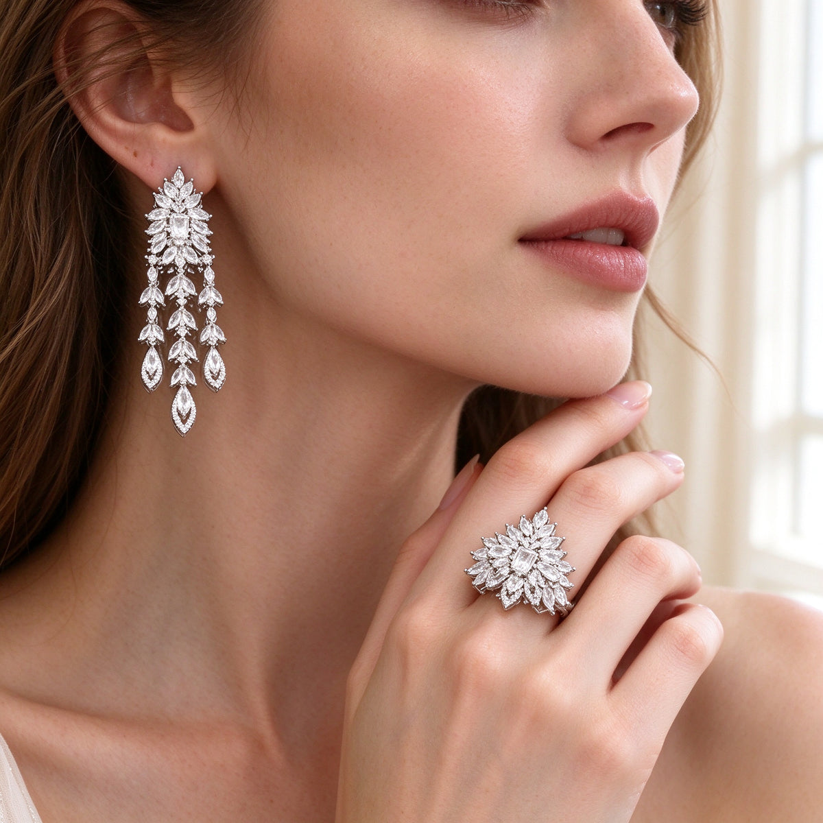 Close-up of tiered chandelier CZ drop earrings and sunburst cluster ring