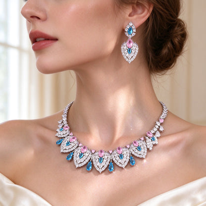 Side detail of The Wren graduated teardrop-panel CZ necklace along the collarbone with pink and blue accent stones