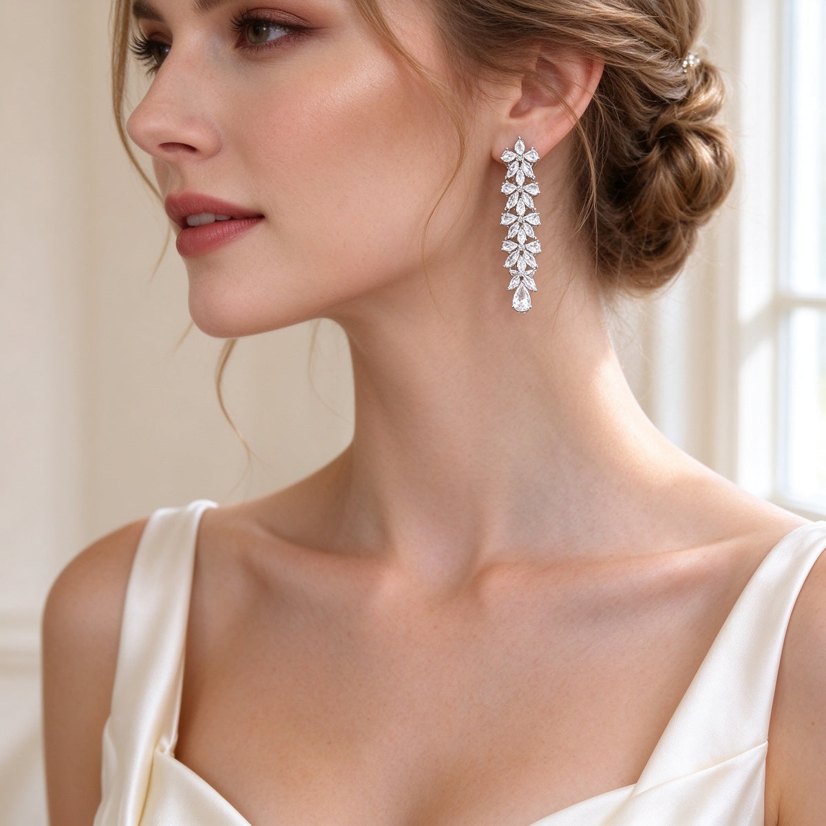 Close-up of The Crest long linear marquise-and-pear CZ drop earrings on a bride