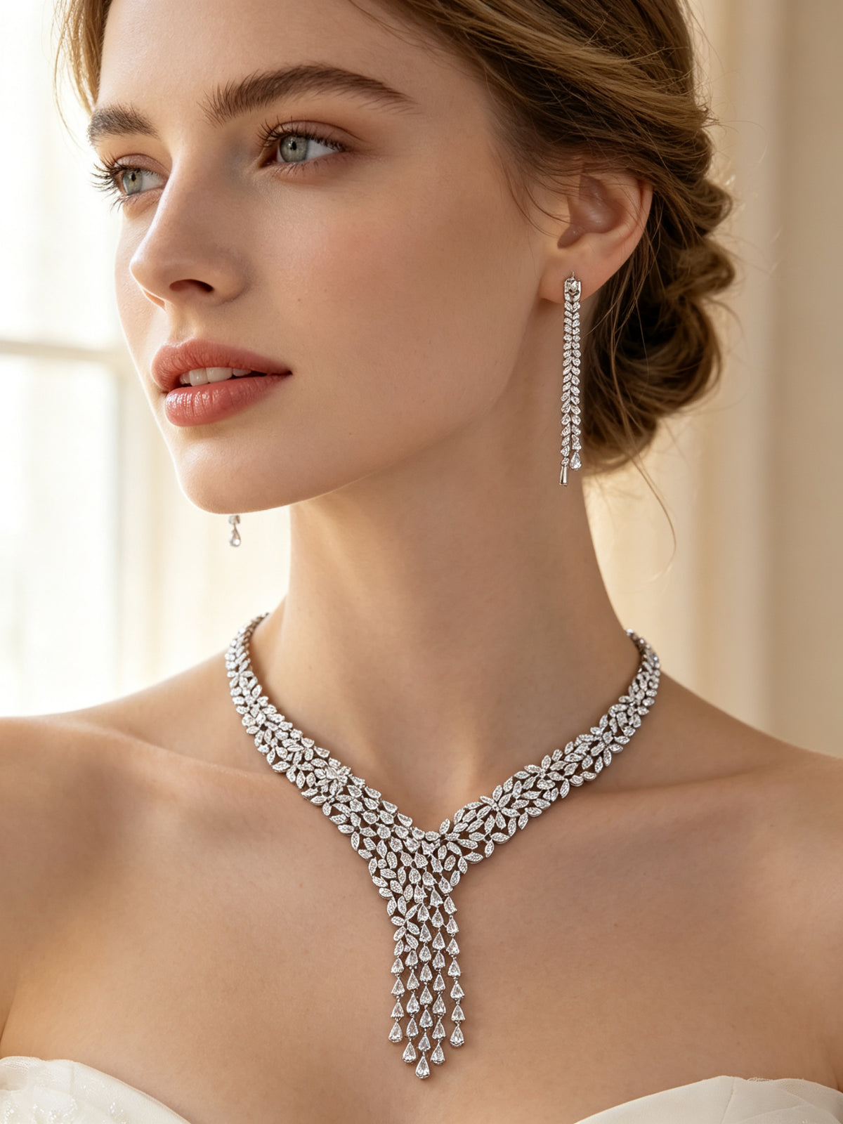 Close-up of the long linear marquise CZ drop earrings worn by a bride in ivory silk