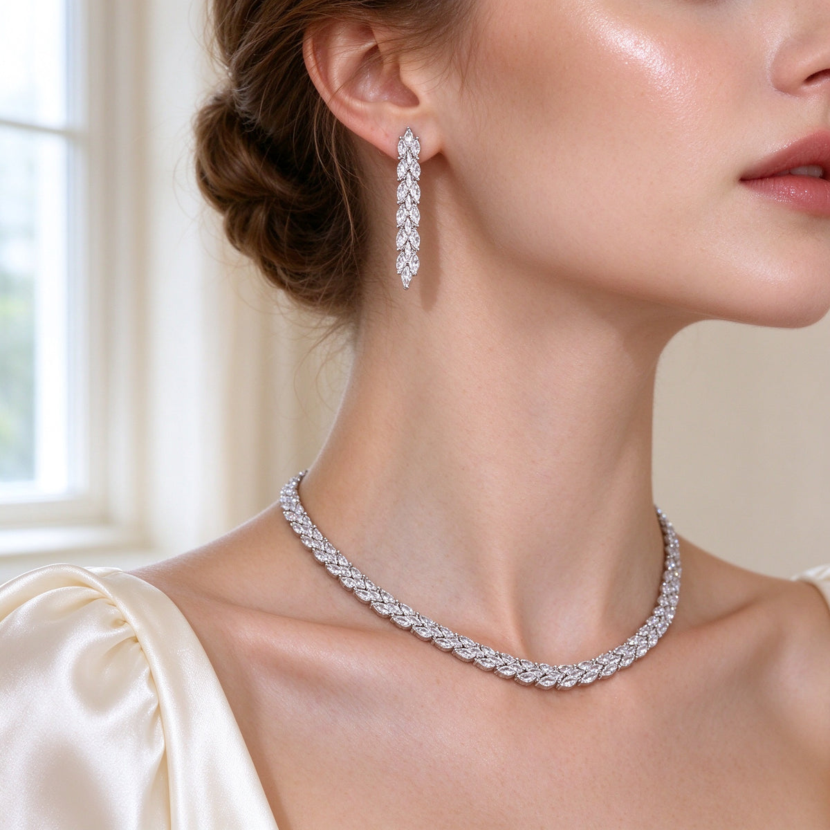 Close-up of The Thorn Wedding Suite linear marquise-drop earring and vine necklace worn at a bride's collarbone