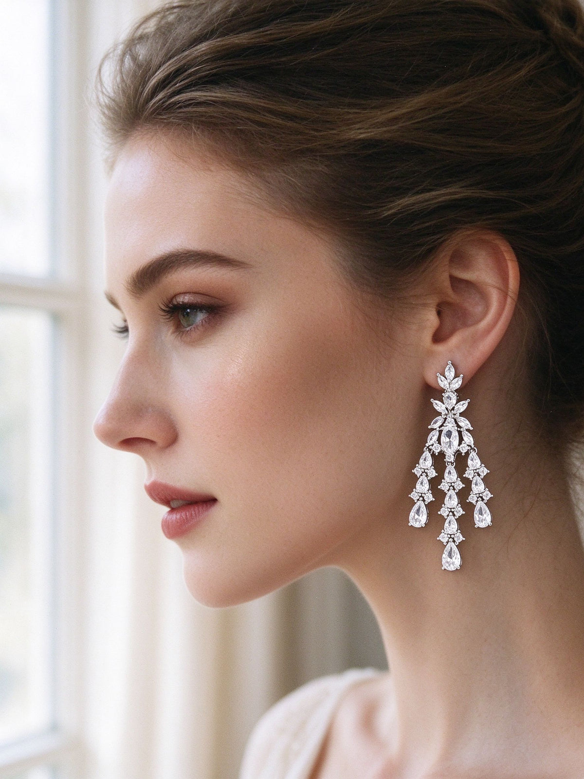 Close-up of bride wearing The Meadow Wedding Suite tiered chandelier CZ earrings