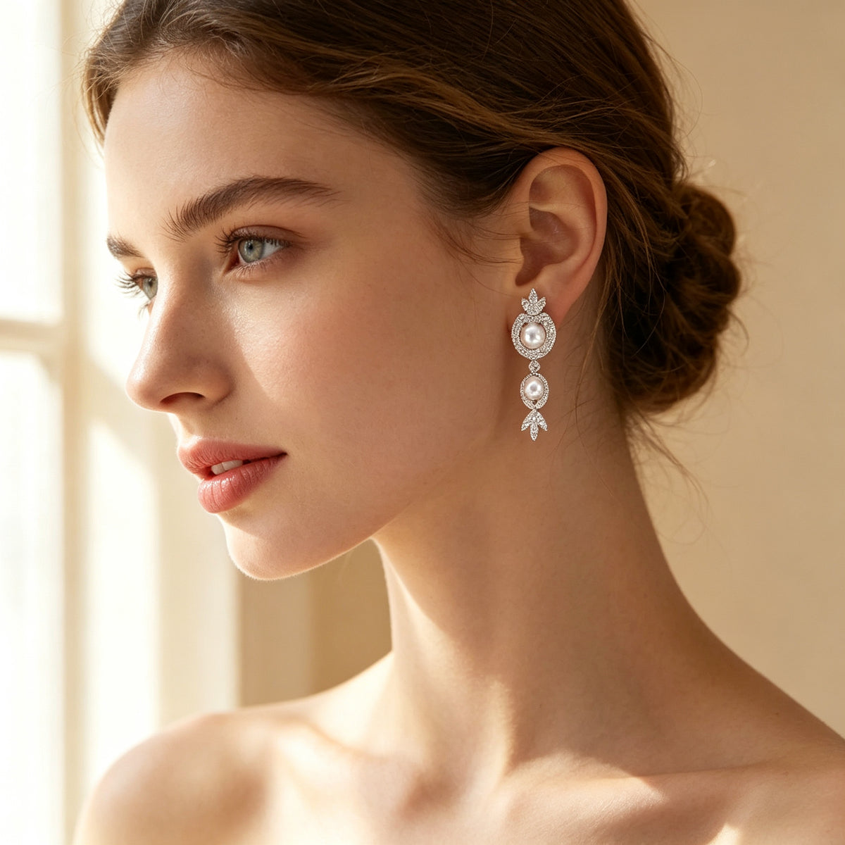 Close-up of pearl and CZ halo drop earrings on a bridal model