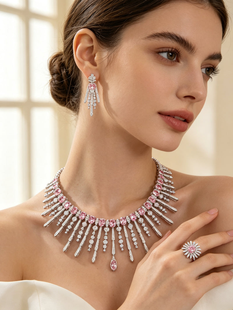Side detail of The Amara Wedding Parure showing the fringe collar on the collarbone, a drop earring and a pink sunburst cluster ring