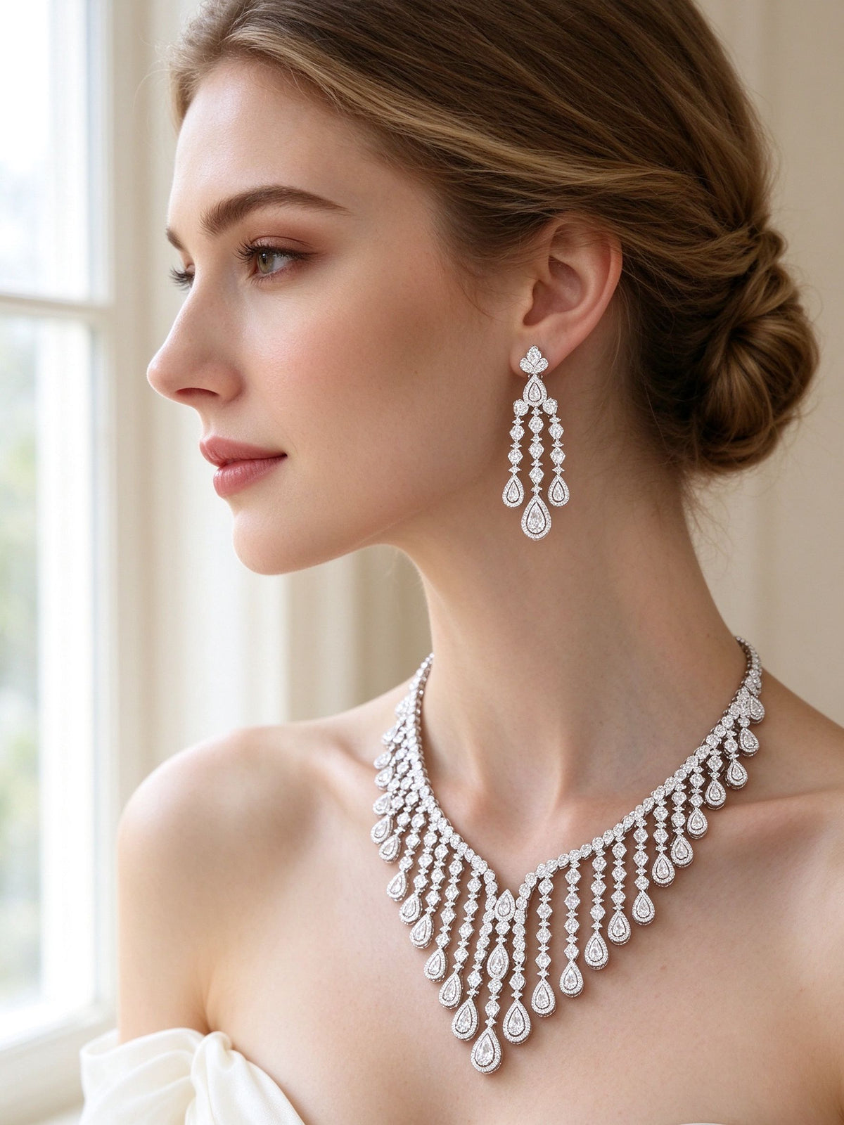Close-up of chandelier CZ drop earrings and bridal necklace worn by bride