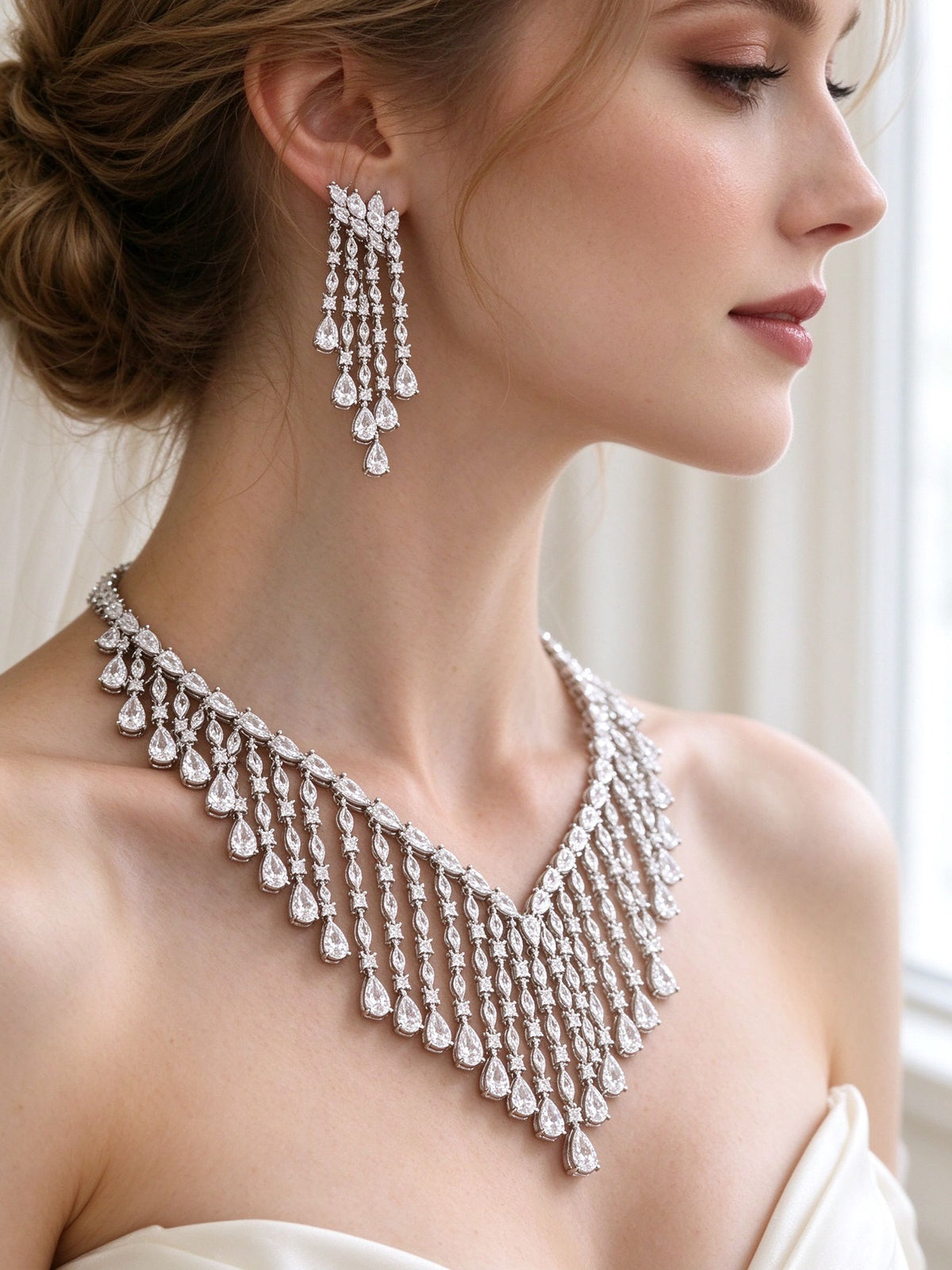 Side detail of The Oriana Crystal Parure showing the long fringe earring and cascading V-fringe necklace at the collarbone