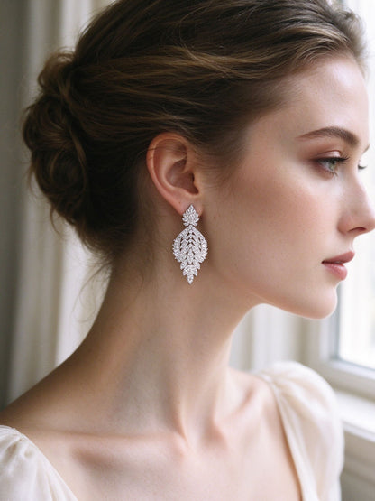 Close-up of bride wearing The Petal Bridal Set micro-pavé teardrop leaf earrings