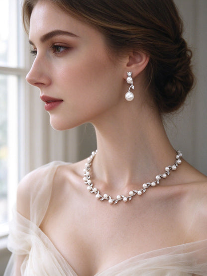 Close-up of bride wearing The Alpine Crystal Parure pearl drop earrings