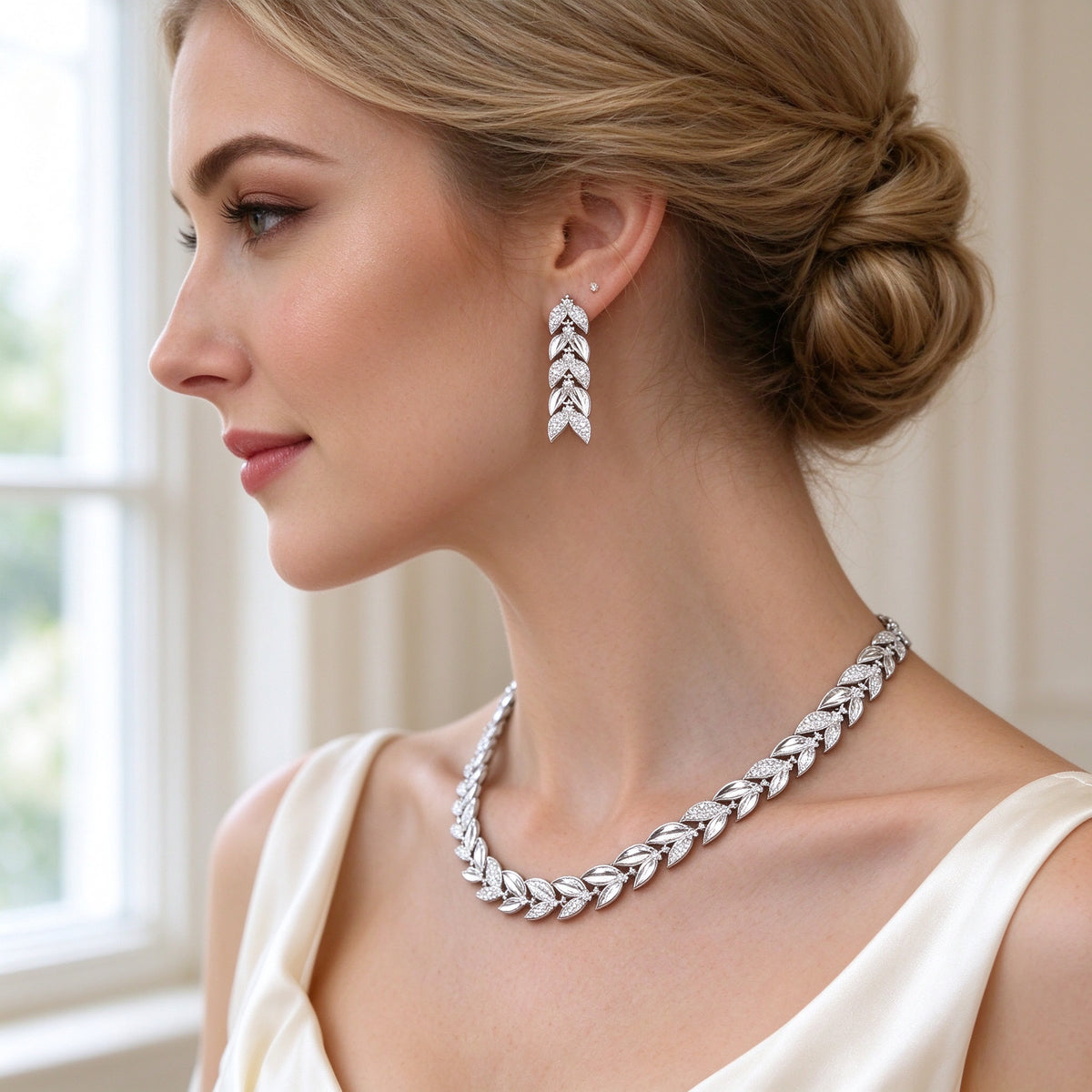 Close-up of a Western bride's ear and neck wearing The Stella Bridal Parure short pavé leaf drop earring and laurel-leaf collar necklace