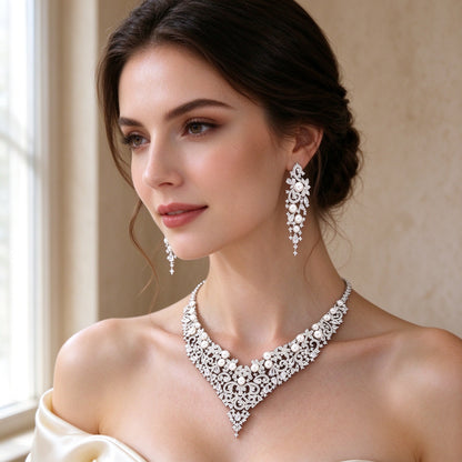 Close-up of bride wearing The Grain filigree CZ and pearl V-neck necklace and chandelier drop earrings
