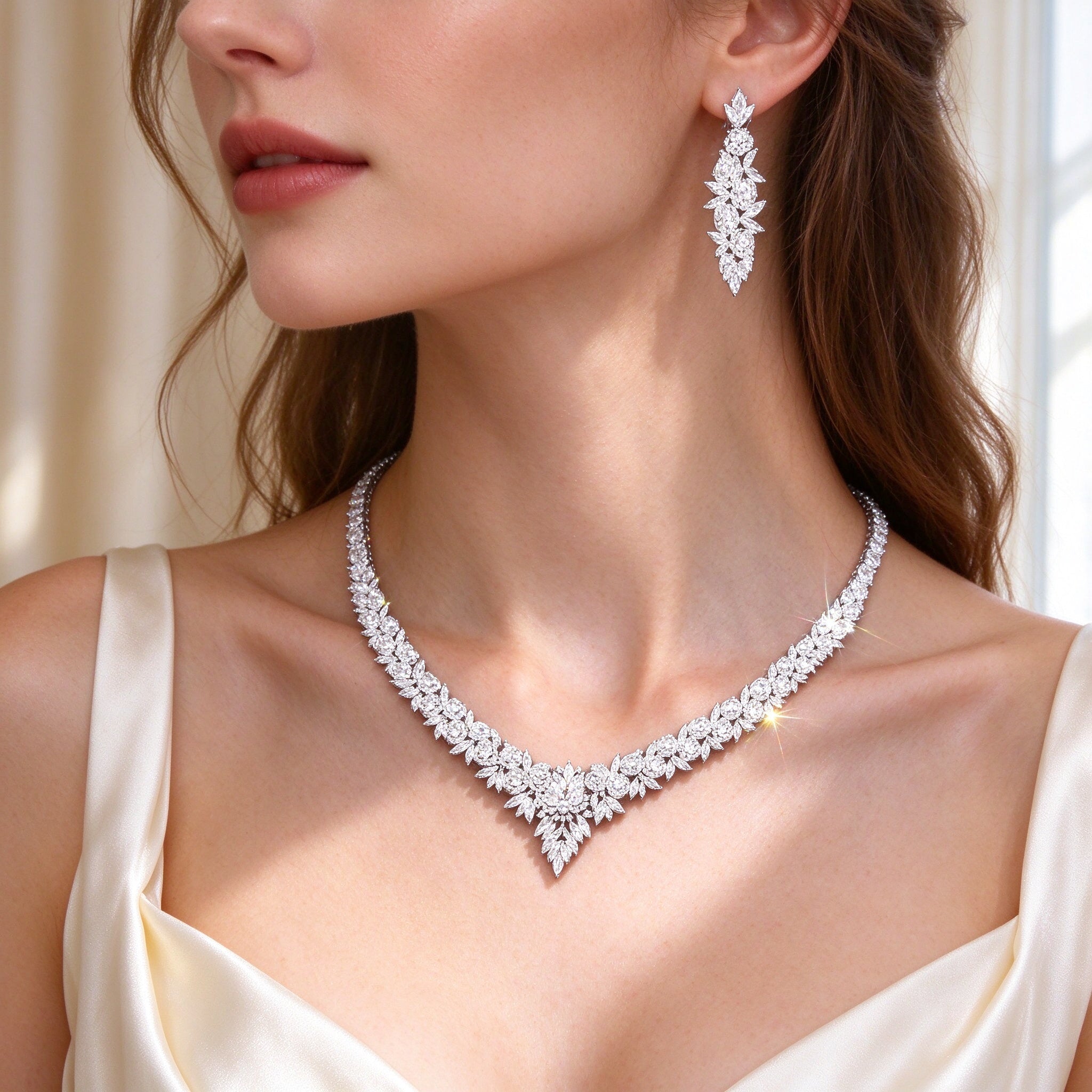 Side detail of The Blair V-shaped graduated marquise CZ necklace along the collarbone and a linear marquise earring