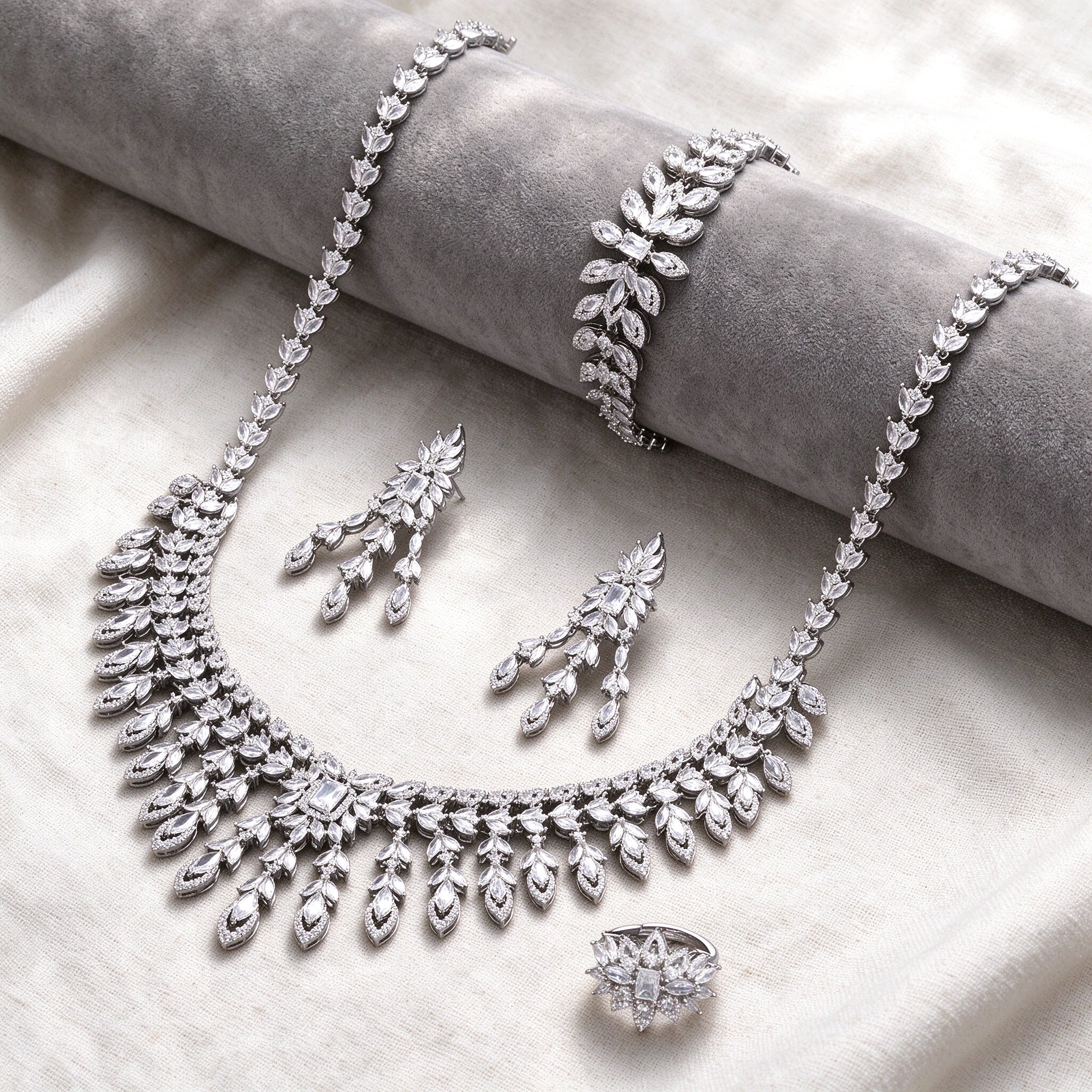 Silver-tone Eve bridal jewelry set flat lay on ivory linen