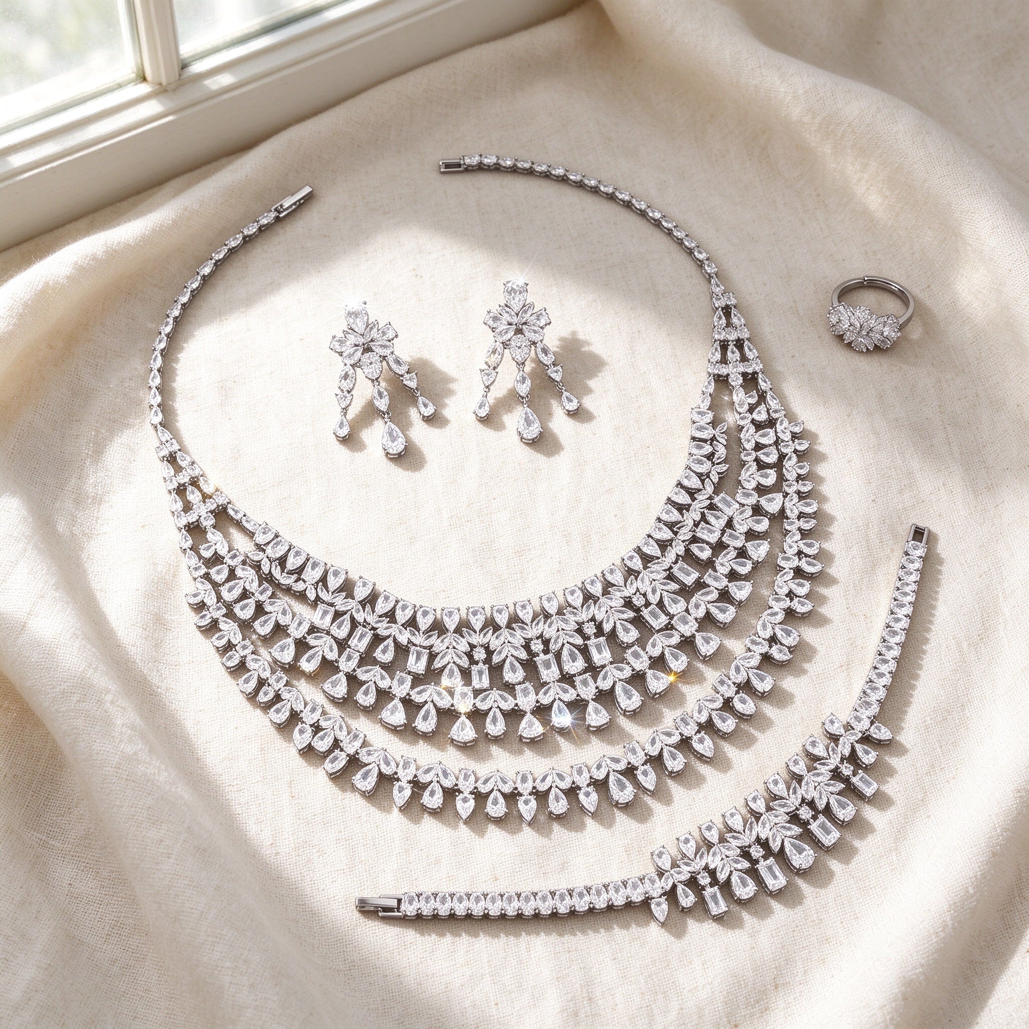 Flat lay of The Fjord Bridal Set on ivory linen — necklace, earrings, bracelet, ring