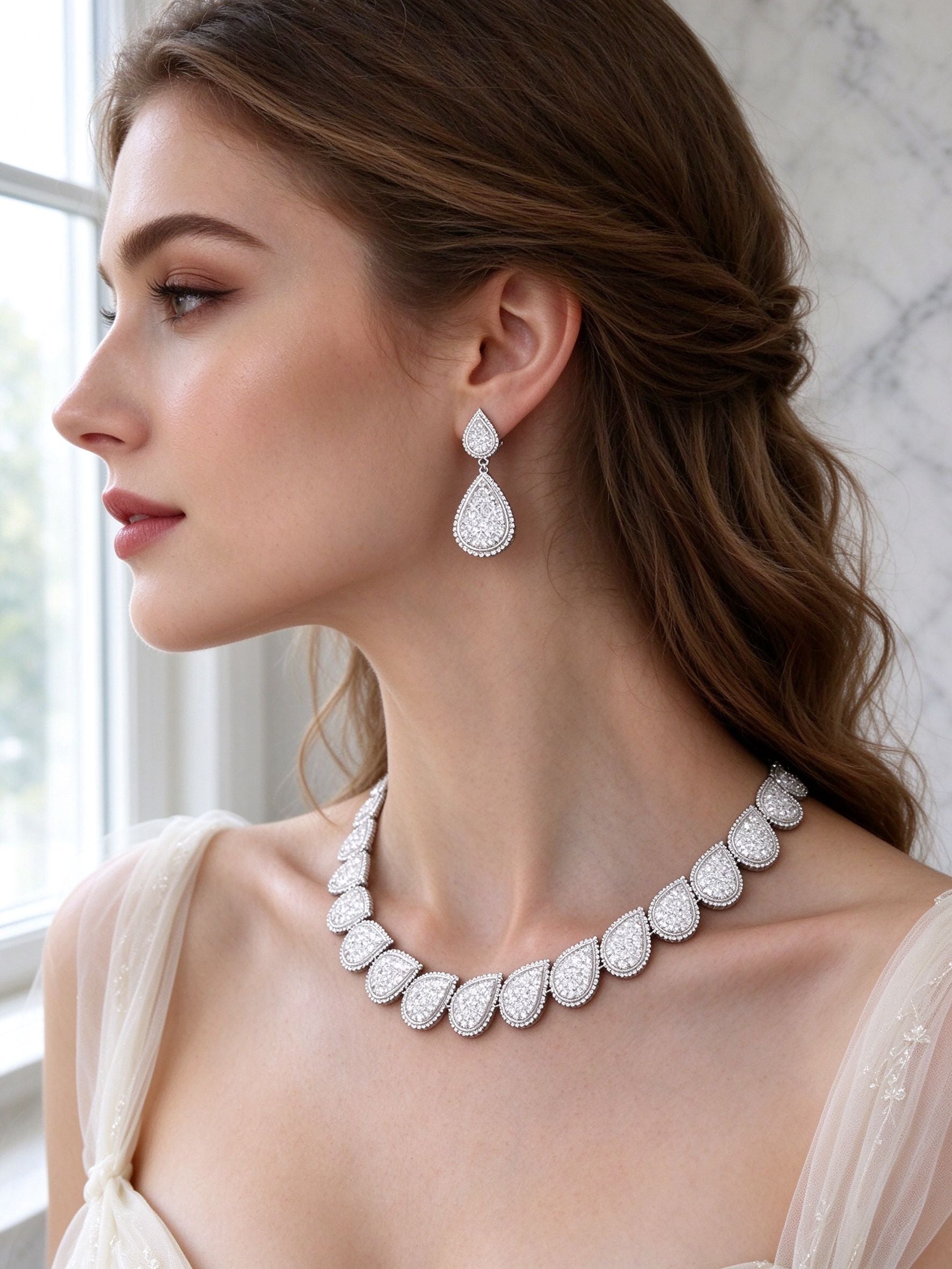 Close-up side profile of woman wearing CZ teardrop earrings and necklace