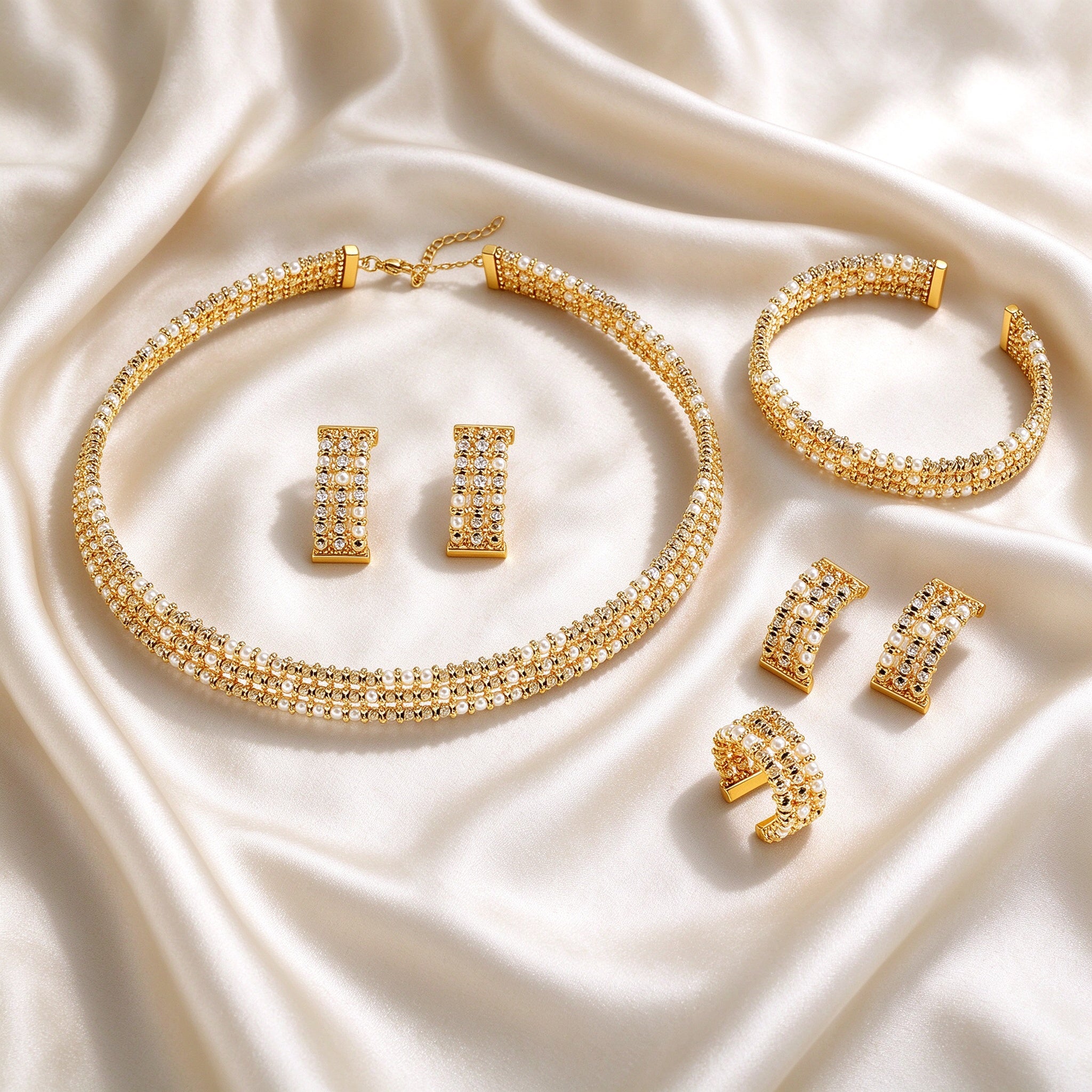 Flat lay of The Isolde Bridal Set four-piece gold-tone set on ivory silk satin