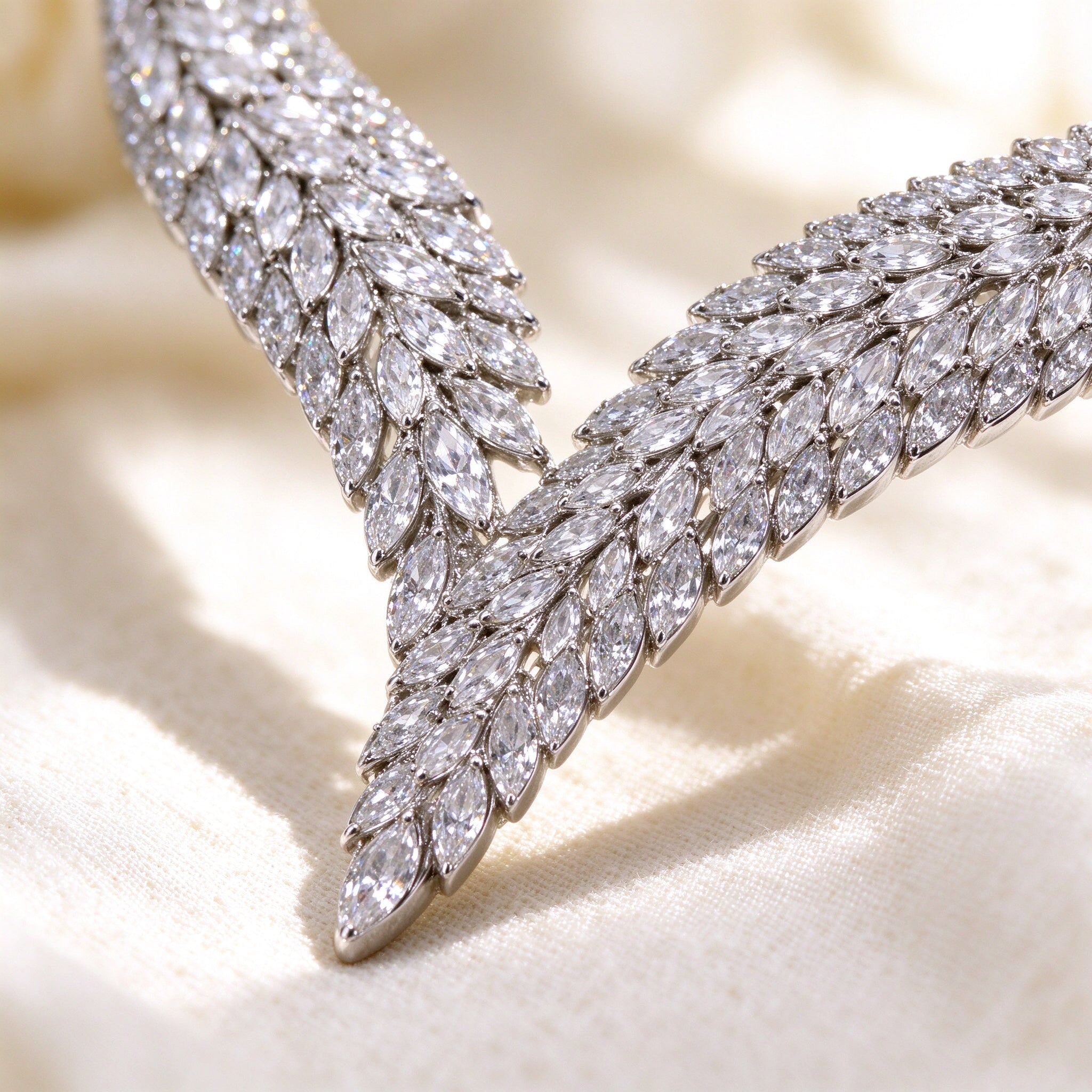 Macro detail of marquise-cut cubic zirconia leaf pattern in silver rhodium
