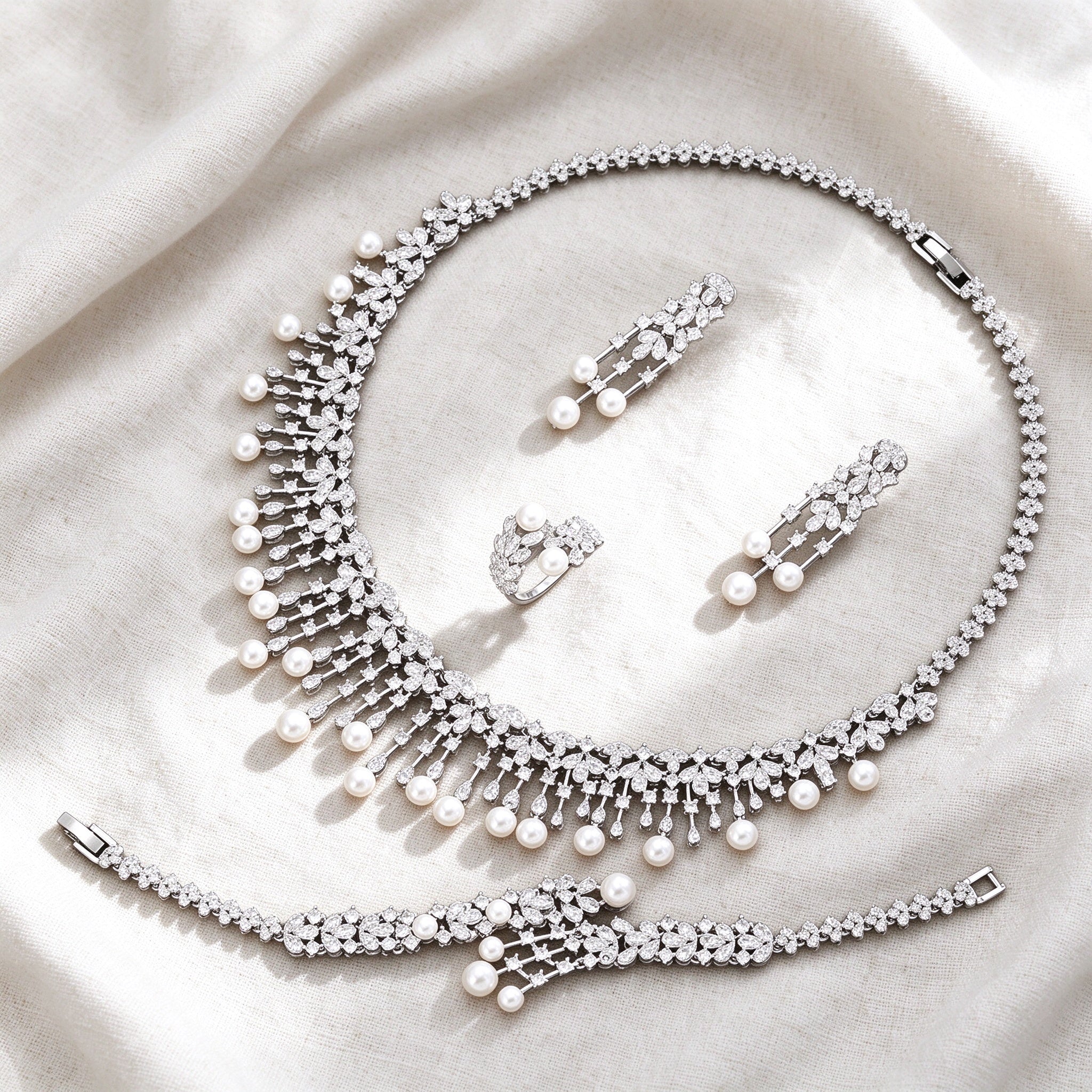 Silver-tone Rue bridal pearl jewelry set flat lay on ivory linen