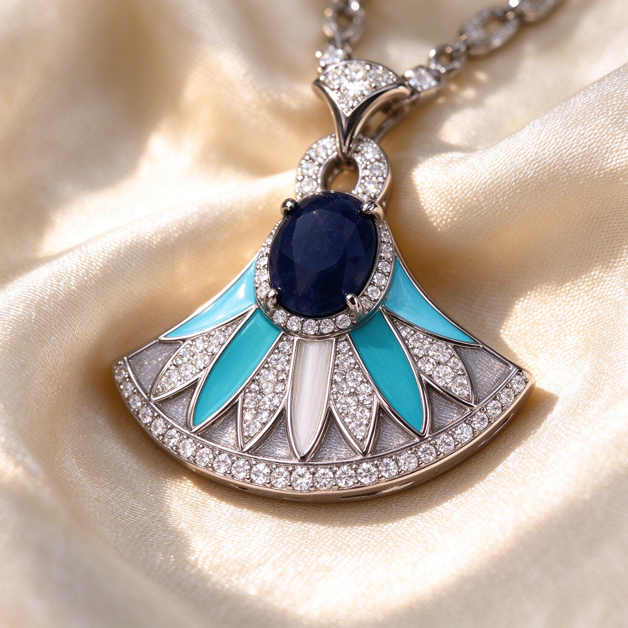 Macro detail of turquoise enamel fan pendant with navy cabochon center and pavé CZ border