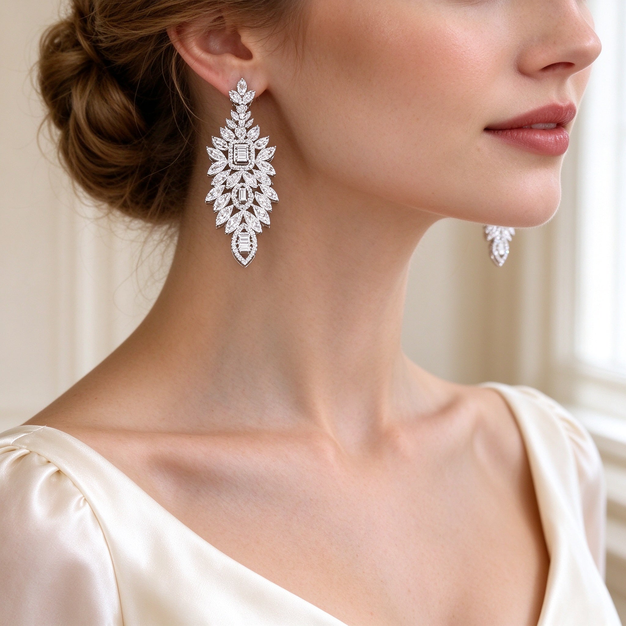 Close-up of The Tiara long leaf-fan marquise and baguette CZ drop earrings on a bride